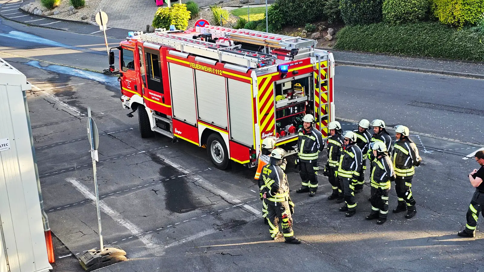 Mannschaft der Freiwilligen Feuerwehr Hertingshausen steht hinter dem Fahrzeug vor dem Gerätehaus bereit zur Übung.