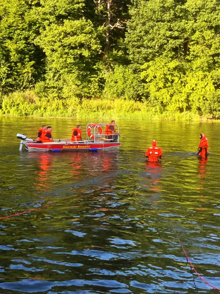 Bootsübung der FW Hertingshausen auf dem Wasser mit Feuerwehrleuten im Boot.