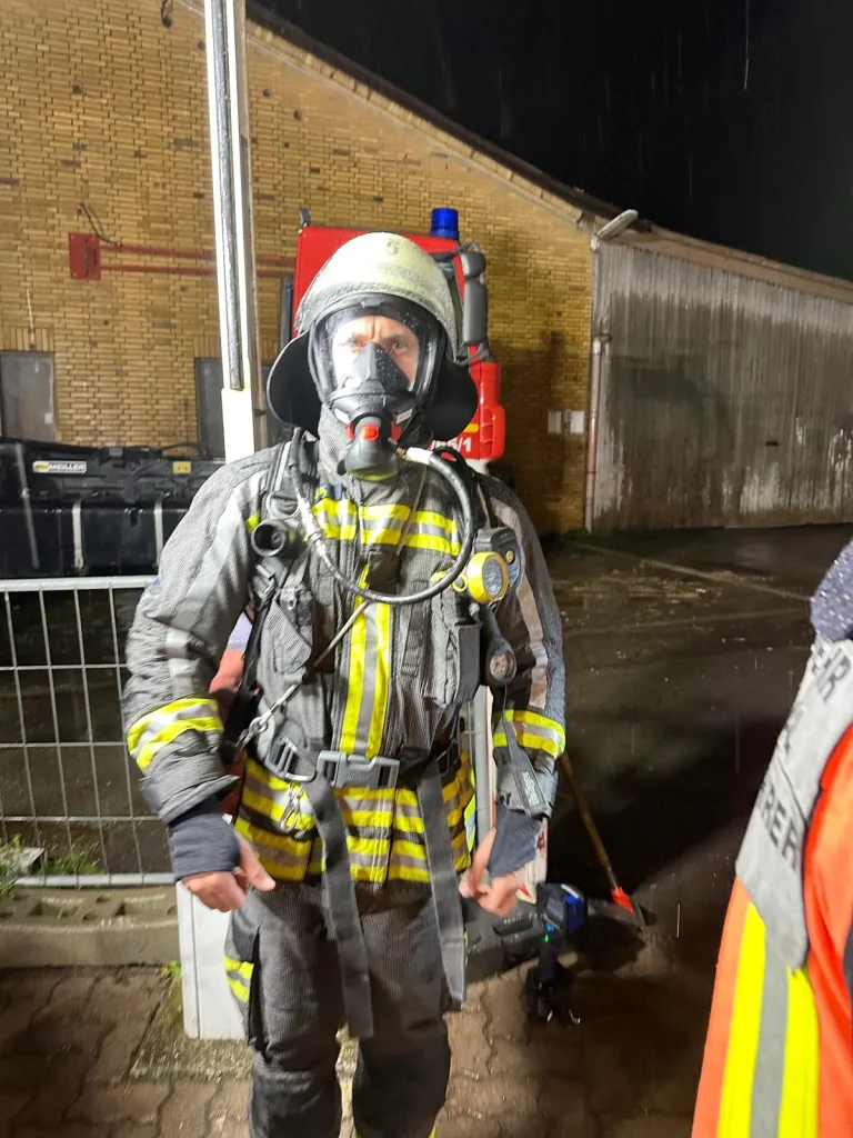 Atemschutzgeräteträger der Freiwilligen Feuerwehr Hertingshausen nach einer Übung, komplett durchnässt.
