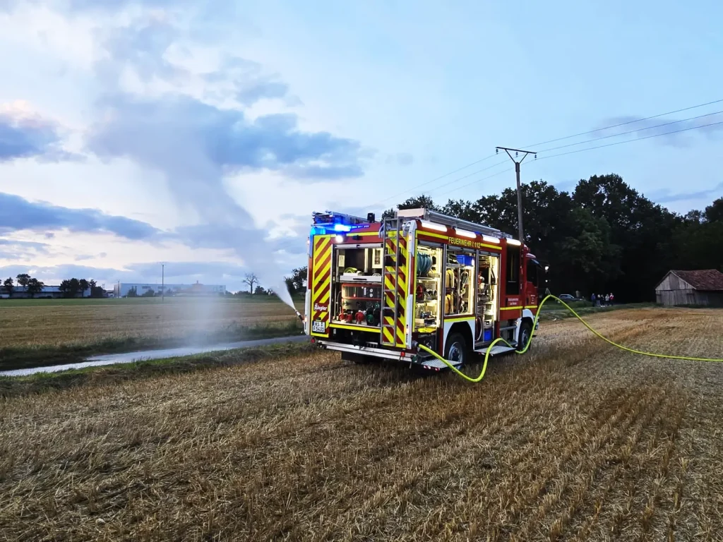 Neues Löschfahrzeug des Katastrophenschutzes der Feuerwehr Hertingshausen spritzt Wasser auf ein Feld.