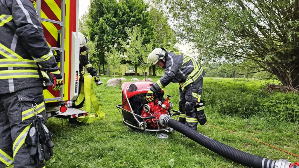 Mobile Wasserpumpe der Freiwilligen Feuerwehr Hertingshausen wird im Grünen gestartet.
